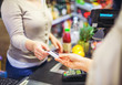 © Karanov images - Woman paying with a credit card in a supermarket closeup