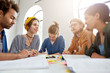 © wayhome.studio  - Young college students from different countries working together sitting at coworking space at table discussing main issues presenting their knowledge in particular sphere exchanging expreience