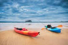 Two Kayaks On The Beach With The Iconic Bass Rock At The Background. Near North Berwick, Scotland, UK