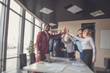 © alfa27 - Happy successful multiracial business team giving a high fives gesture as they laugh and cheer their success
