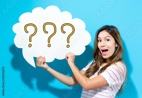 Question Mark text with young woman holding a speech bubble on a blue background Wallpaper Mural