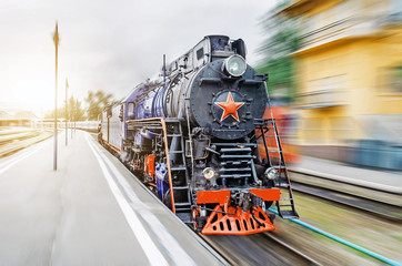 Vintage black steam locomotive train rush railway. The concept of tourism is a retro journey by train