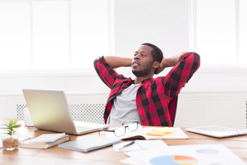 Wall Mural - Young relaxed businessman with laptop in modern white office