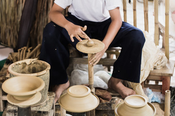 senior asian handcraft potter making clay pot earthware by hand.