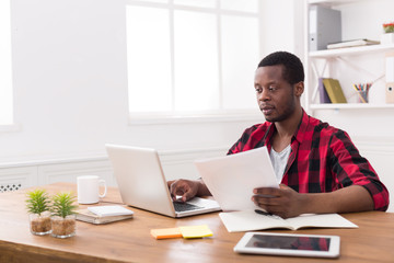 Wall Mural - Black businessman in casual office, work with laptop and documents