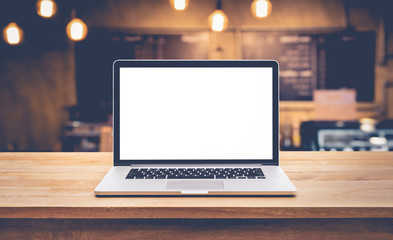 Wall Mural - Modern computer,laptop with blank screen on table with blur cafe,restaurant background