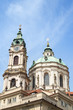 View of tower and dome of Church of Saint Nicholas (St. Nicholas Church) in Mala Strana or Lesser Town in Prague, Czech Republic, in the daytime.