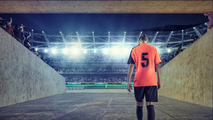 female soccer player entering the field on crowded stadium