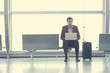© wong yu liang - Asian Indian business man sitting on chair and using laptop while waiting his flight at airport.