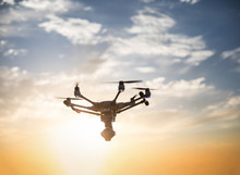 Futuristic Flying Drone With Stabilizer Camera On A Spectacular Sunset Sky