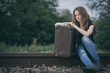 © altanaka - Portrait of young sad ten girl standing with suitcase outdoors at the day time.