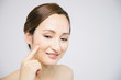 © metamorworks - beauty woman who checks her skin, skin care, acne treatment