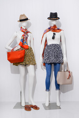 Wall Mural - full-length female in jeans clothing with hat and scarf ,shoes ,handbag on two mannequin

