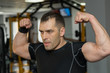 © lenblr - Young muscular man flexing his biceps in gym