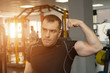 © lenblr - handsome athletic young man showing his biceps posing in gym