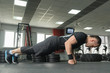 © lenblr - Fitness man doing exercise push-ups on fists intense training in gym
