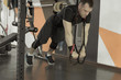 © lenblr - Strong man doing push-ups with fitness straps in gym.