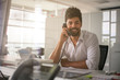 © liderina - Business man working in office. Man talking on Landline phone.