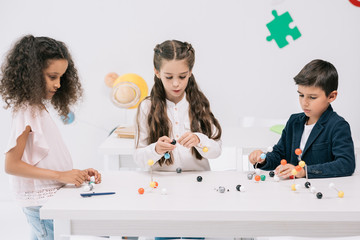 Wall Mural - Concentrated multiethnic pupils working with molecular model at chemistry class