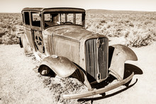 An Abandoned Antique Car Near A Dessert Roadway