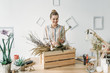 © LIGHTFIELD STUDIOS - happy attractive female florist with dry flowers at workplace