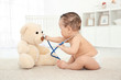 © Africa Studio - Cute little baby with stethoscope and toy bear playing at home