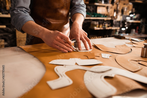 Fotografía Close up of a shoemaker measuring and cutting leather