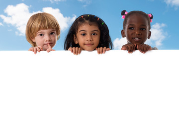 Wall Mural - Group of multiracial kids portrait with white board