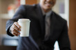 © Sura Nualpradid - Businessman in suit holding white paper coffee cup
