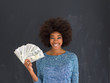 © .shock - black woman holding money on gray background