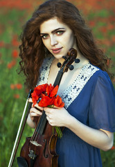 Wall Mural - Beautiful romantic girl with red hair and blue dress holding violin on nature field of poppy flowers. Photo of sensual woman.