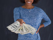 © .shock - black woman holding money on gray background