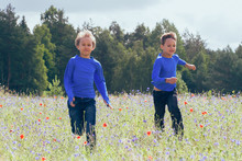 Happy Kids Running On Meadow In Sunny Day