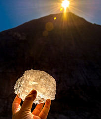 pice of the briksdal glacier held up by hand in the setting sun in Norway