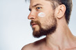 © SHOTPRIME STUDIO - Young guy with beard on white isolated background, face cream