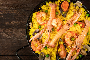 Wall Mural - Closeup of Spanish seafood paella in paellera with copyspace