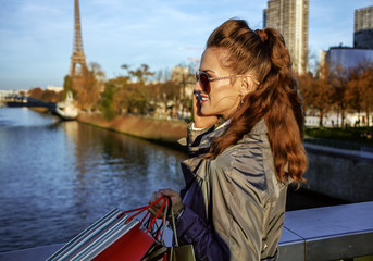 young fashion-monger speaking on smartphone near Eiffel tower