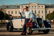 © Nejron Photo - Confident wealthy young man with briefcase near classic convertible