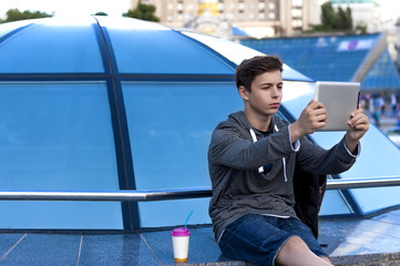 young man with a tablet near a blue glass dome