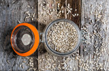Fototapeta Mapy - Peeled sunflower seeds in rustic jar on wooden table, healthy vegan cooking ingredient, top view