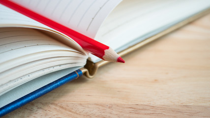 Red color pencil stand on blank notebook 2