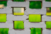 Abstract Green View Through White Brick Fence
