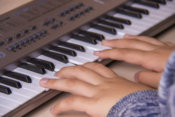 Beautiful girls hands playing electronic piano keyboards.