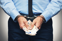 Corruption And Bribery Concept - Arrested Official With Money In Hands