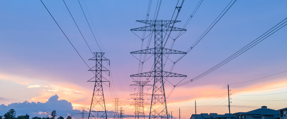 Group silhouette of transmission towers (power tower, electricity pylon, steel lattice tower) at twilight in US. Texture high voltage pillar, overhead power line, industrial background. Panorama style