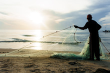 Silhouette Fisherman Working On Beach