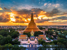 Large Golden Pagoda Located In The Community At Sunset , Phra Pathom Chedi , Nakhon Pathom , Thailand .The Measure Public.Aerial View.Cloudy Skies And Golden.