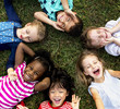 © Rawpixel.com - Group of kindergarten kids lying on the grass at park and relax with smiling