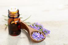 True Lavender Essential Oil And Flowers On The Wooden Table