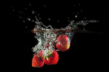 Wall Mural - Strawberries splashing into water